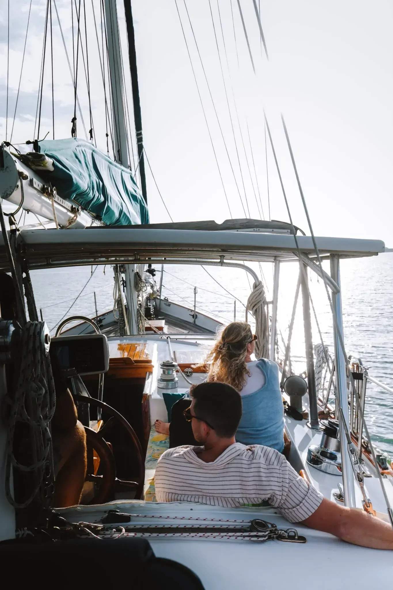 Couple relaxing in the cockpit at sunset aboard SV Cay Michele